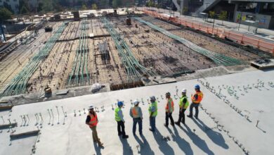seven construction workers standing on white field