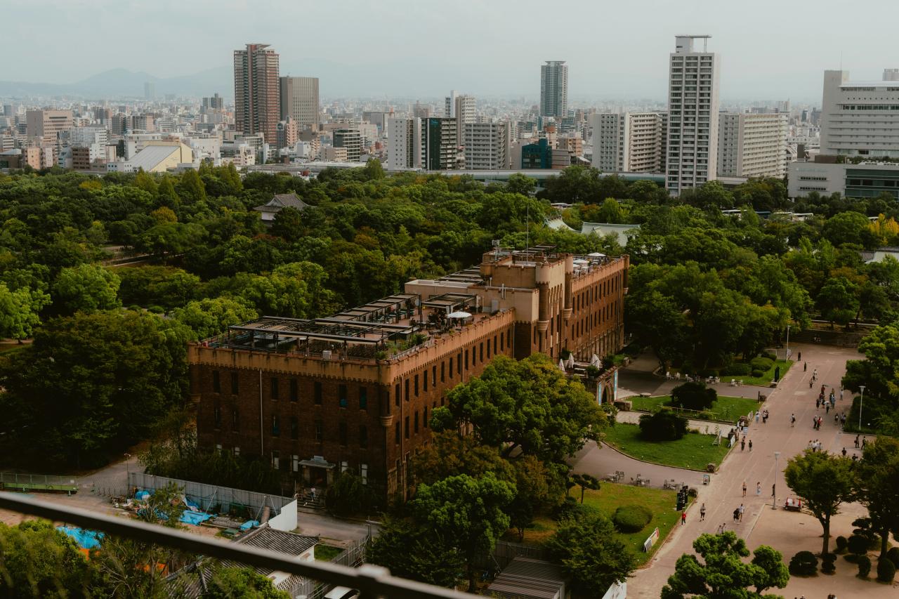 Historic building surrounded by lush green park and cityscape.