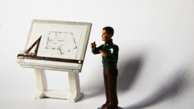 a toy man standing next to a miniature easel