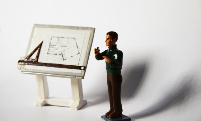 a toy man standing next to a miniature easel